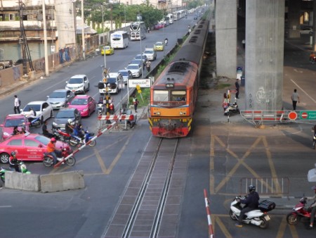 An ordinary train passing the Asok Din Daeng level crossing in Bangkok
